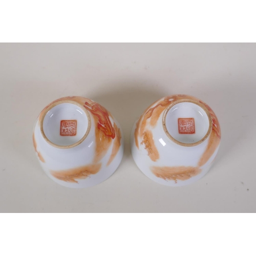 35 - A pair of early C20th Chinese red and white porcelain tea bowls with fo dog decoration highlighted w... 