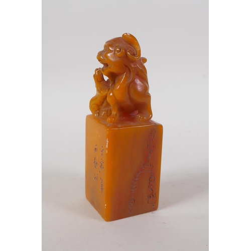 43 - A Chinese amber soapstone seal with carved kylin knop and character inscription to side, 12cm high