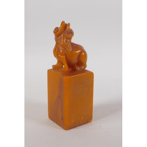 43 - A Chinese amber soapstone seal with carved kylin knop and character inscription to side, 12cm high