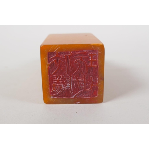 43 - A Chinese amber soapstone seal with carved kylin knop and character inscription to side, 12cm high