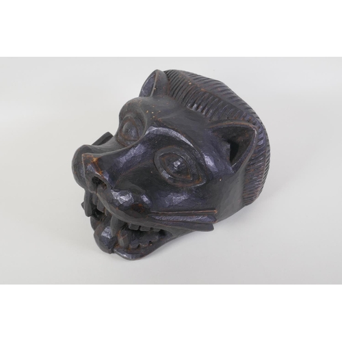 44 - An African Benin carved wood lion helmet/mask, 30 x 23cm