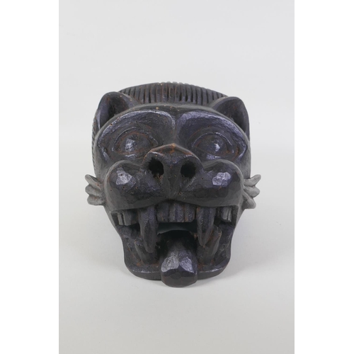 44 - An African Benin carved wood lion helmet/mask, 30 x 23cm