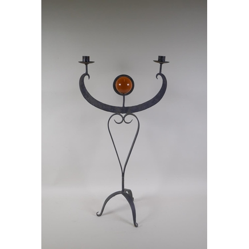 51 - A wrought metal two branch candle sconce inset with a decorative amber glass ball, 63cm high