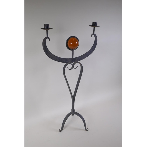 51 - A wrought metal two branch candle sconce inset with a decorative amber glass ball, 63cm high