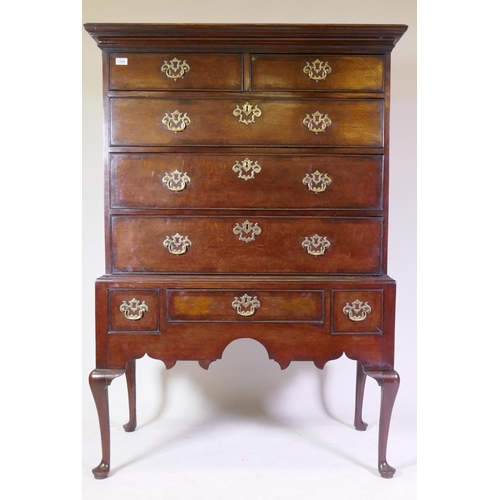 1004 - A Georgian oak chest on stand, with mahogany crossbanded drawers, cabriole legs and pad feet, 107 x ...