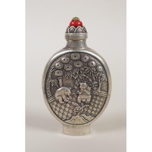 130 - A Chinese white met5al snuff bottle, with decorative raised panels depicting pandas, impressed marki... 