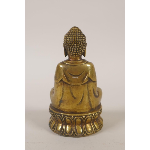 179 - A Sino-Tibetan filled gilt metal figure of Buddha, double vajra mark to base, 11cm high