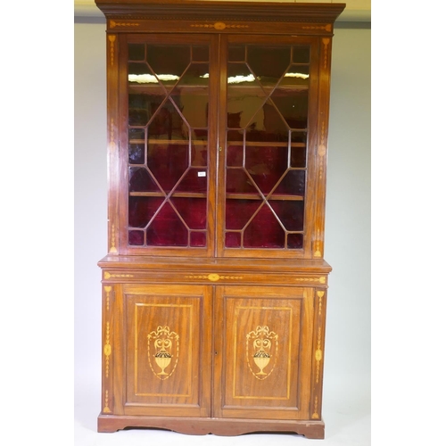 1017 - A Victorian inlaid mahogany bookcase in two sections, the upper with astral glazed doors, the lower ...