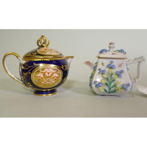 297 - A Continental Augustus Rex porcelain miniature teapot with raised floral decoration and a Vienna jug... 