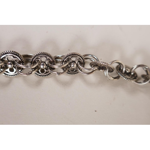 606 - A Chinese white metal 'Hmong' charm necklace with filigree decoration of dragons and flowers, 19cm w... 