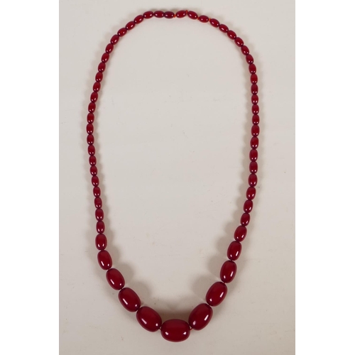 614 - A vintage graduated cherry amber necklace, 82cm long, 81g