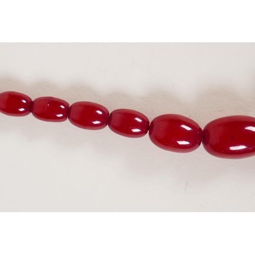 614 - A vintage graduated cherry amber necklace, 82cm long, 81g