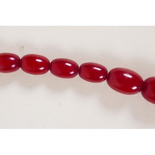 614 - A vintage graduated cherry amber necklace, 82cm long, 81g