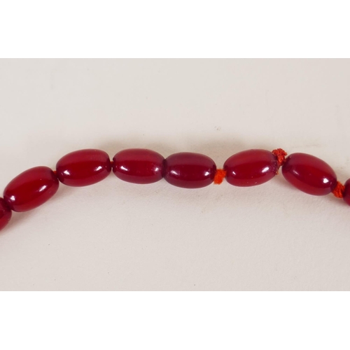 614 - A vintage graduated cherry amber necklace, 82cm long, 81g