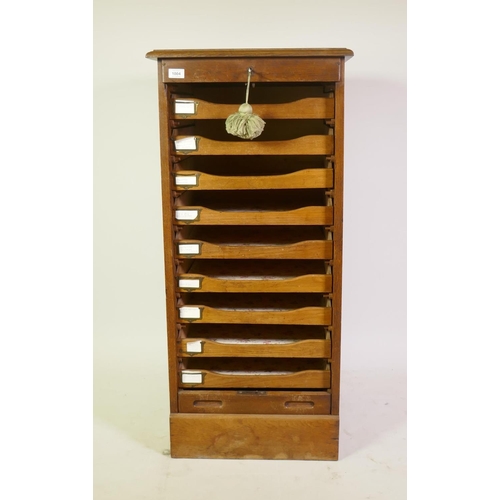 1004 - Early C20th oak office filing cabinet with tambour front and nine slide drawers, 50 x 53 x 110cm
