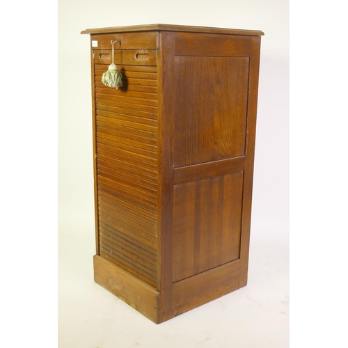 1004 - Early C20th oak office filing cabinet with tambour front and nine slide drawers, 50 x 53 x 110cm