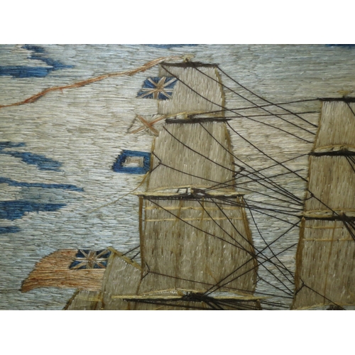 162 - A 19TH CENTURY SAILOR'S SILKWORK PICTURE depicting a fully rigged frigate with red ensign sailing of... 