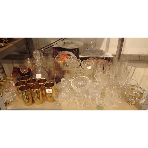 84 - Shelf of mixed glassware including cake plate, decanters, drinking glasses etc