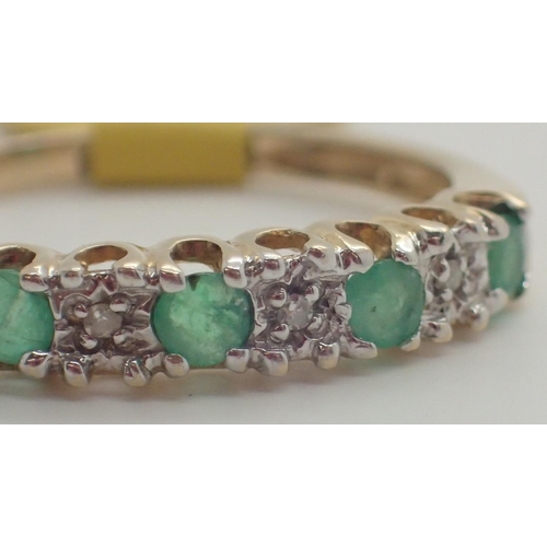 1037 - 9ct gold emerald and diamond half eternity ring size P