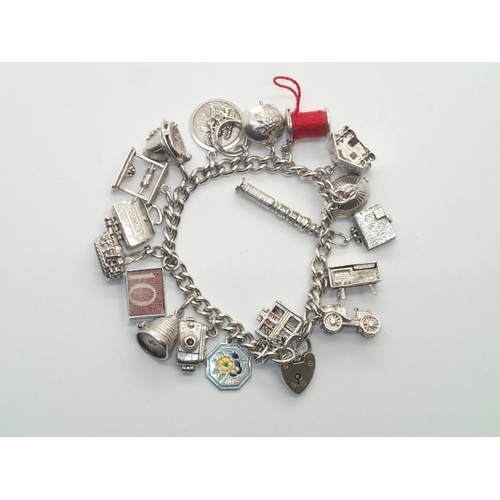 191 - Heavy vintage silver charm bracelet with 19 charms with many Nuvo examples, including rare cotton re... 