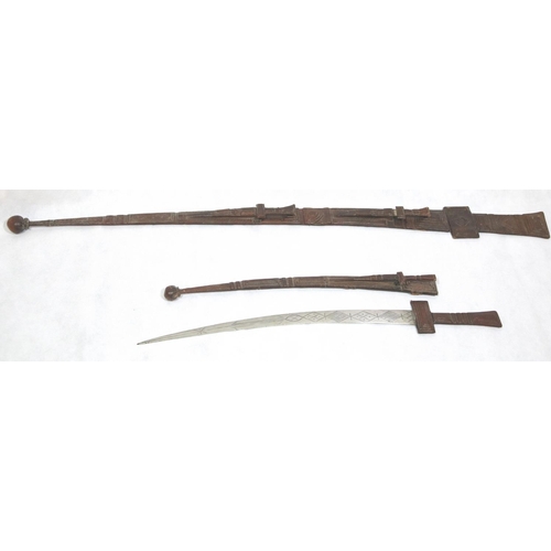 1620 - Two North African swords in elaborate leather scabbards with leather grips. P&P Group 3 (£25+VAT for... 