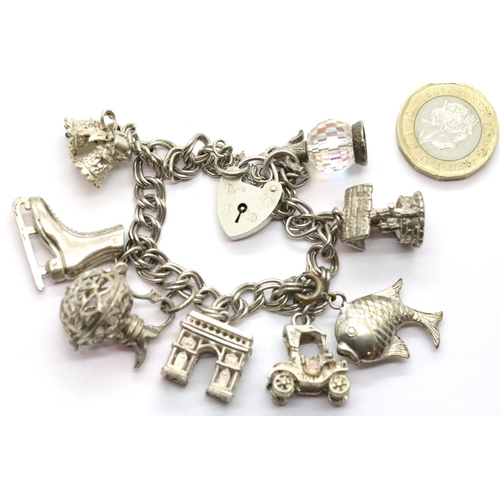 1016 - Silver charm bracelet with padlock clasp with eight charms, 46g. P&P Group 1 (£14+VAT for the first ... 