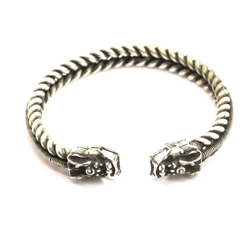 1042 - White metal Tibetan silver twisted bangle with heavy dragon finials. P&P Group 1 (£14+VAT for the fi... 