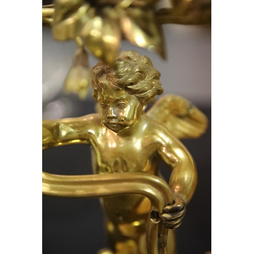 1436 - 19th century gilt bronze two sconce candelabra, the body in the form of a putti grasping a floral vi... 