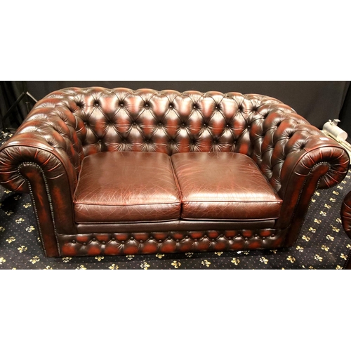 1702 - Red leather button back two seater settee in good condition. Not available for in-house P&P