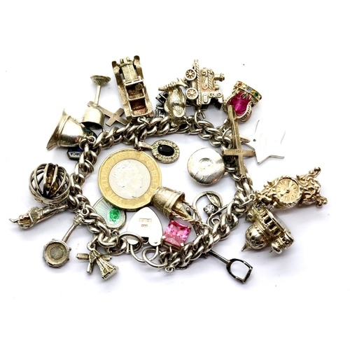 1123 - Silver charm bracelet with twenty four charms, 86g. P&P Group 1 (£14+VAT for the first lot and £1+VA... 