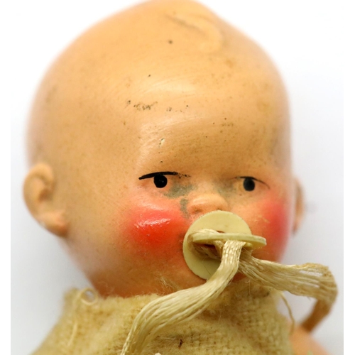 1311 - Antique German ceramic baby figurine with original clothing. P&P Group 1 (£14+VAT for the first lot ... 