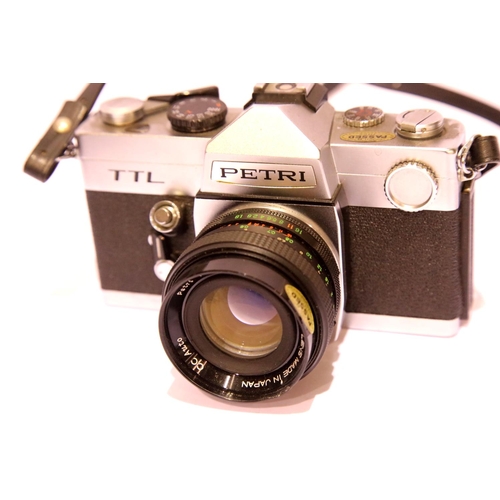 1438 - Three SLR film cameras and accessories, two Petri SLR and Canon compact film camera. P&P Group 3 (£2... 