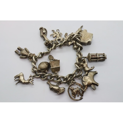 15 - Silver charm bracelet with 14 charms, 77g. P&P Group 2 (£18+VAT for the first lot and £3+VAT for sub... 