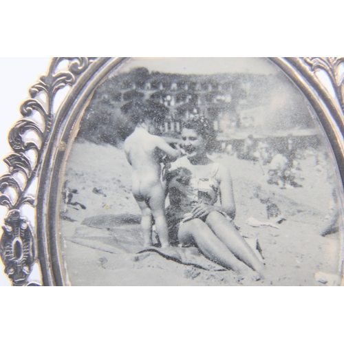 99 - Small oval silver photo frame with decorated foliage border. P&P Group 1 (£14+VAT for the first lot ... 