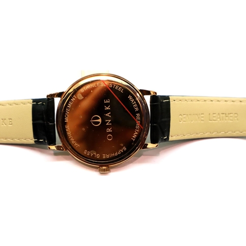 132 - New and boxed black face gold tone Ornake wristwatch with seconds dial and leather strap. P&P Group ... 