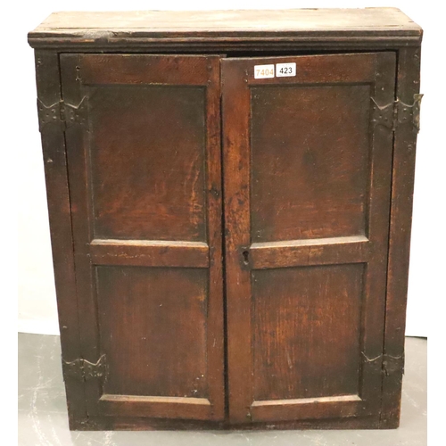 423 - An 18th Century Provincial oak two door spice cabinet, the interior fitted with shelves, the shell p... 