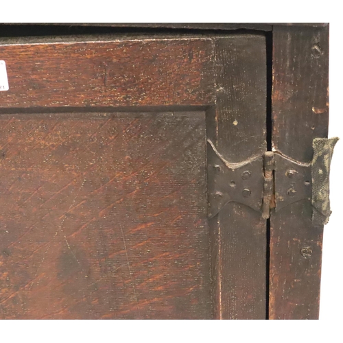 423 - An 18th Century Provincial oak two door spice cabinet, the interior fitted with shelves, the shell p... 