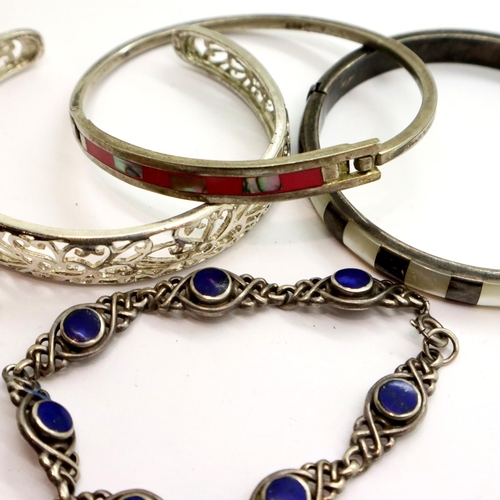 82 - Two stone set 925 silver snap bangles, a further silver bangle and a lapis lazuli set silver bracele... 