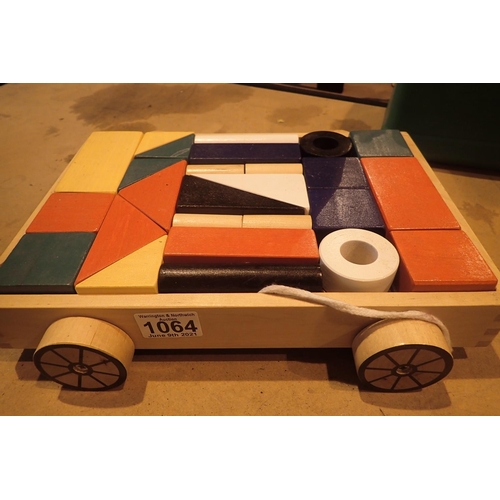 1064 - A wooden pull along trolley containing coloured childrens building blocks. Not available for in-hous... 