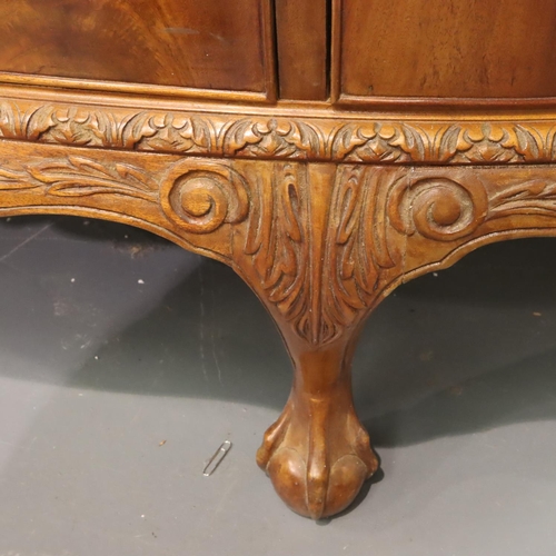 543 - A 20th century walnut three drawer, two door sideboard in the Epstein style, raised on claw and ball... 