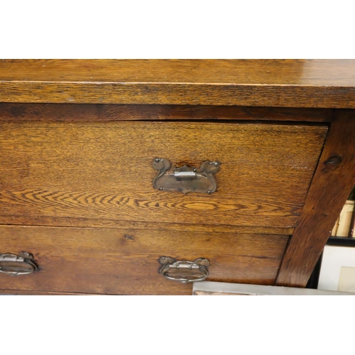 557 - An Arts and Crafts oak dresser, the sideboard base asymmetric with drawers and cupboard, plate rack ... 