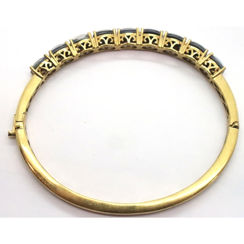 77 - Yellow metal stone set snap bangle marked Karis, 12g. P&P Group 1 (£14+VAT for the first lot and £1+... 