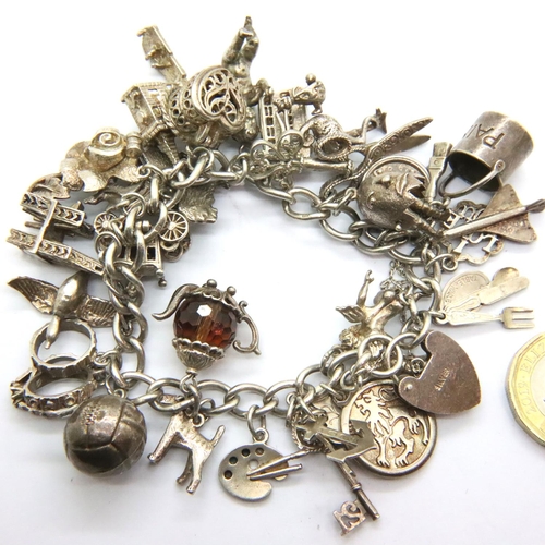 36 - 925 silver charm bracelet with padlock clasp and 29 charms, combined 91g. P&P Group 1 (£14+VAT for t... 