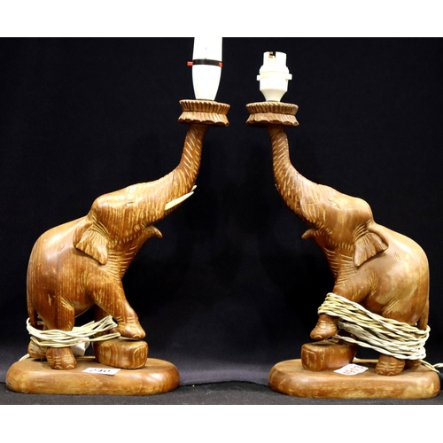 240 - A pair of mid 20th Century carved teak lamp bases in the form of elephants, each H: 34 cm (excluding... 