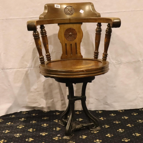 492 - Oak smokers bow type armchair on a cast iron pedestal base, H: 84 cm. Not available for in-house P&P... 