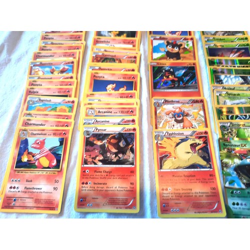 2130 - Collection of assorted Fire and Grass Pokemon trading cards including shiny / holographic examples; ... 