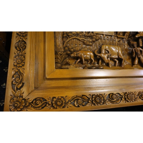 500 - A deeply carved substantial Oriental hardwood dining table with plate glass top displaying figures a... 