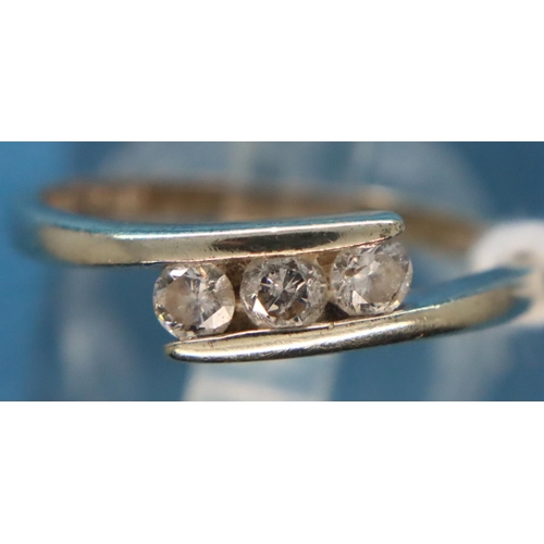 65 - 9ct white gold three stone (totalling 0.25cts) diamond crossover ring, size K, 1.8g. P&P Group 1 (£1... 