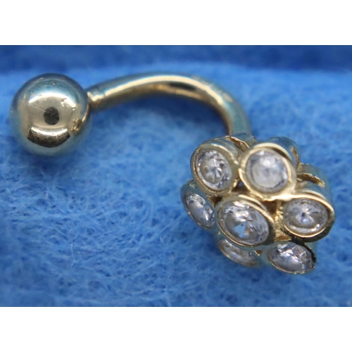 69 - Hallmarked 9ct gold and diamond seven stone daisy set belly stud, 1.8g. P&P Group 1 (£14+VAT for the... 