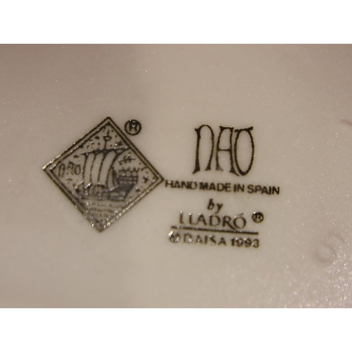 182 - Lladro figurine girl with posy, a further Lladro girl with a chamberstick and a Nao girl, H: 26 cm. ... 